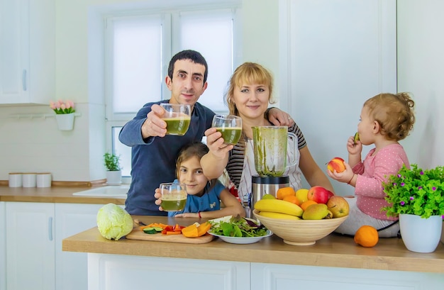 Семья готовит смузи на кухне. Выборочный фокус.