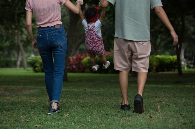 a family is playing in the grass with their parents