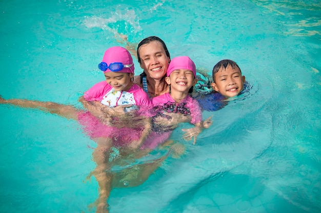 Family kids swimming and playing in swimming pool on summer