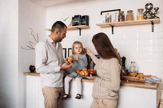 Family in kitchen during morning breakfast together. 