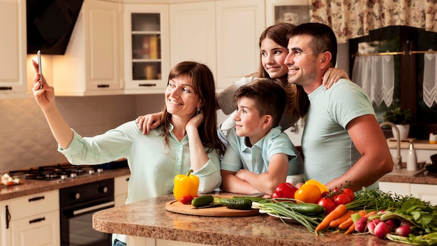 Foto famiglia in cucina prendendo un selfie