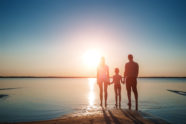 Family on the lake against a beautiful sunset. 