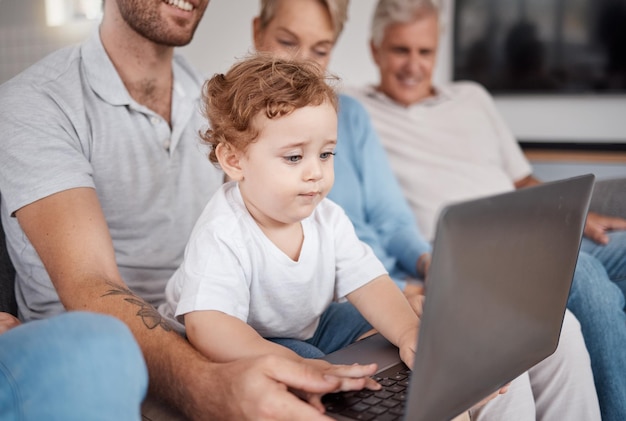 Foto laptop di famiglia e bambino in soggiorno che imparano a scrivere o giocare educazione della grande famiglia e sviluppo di un bambino o di un bambino al computer con padre, nonna e nonno a casa