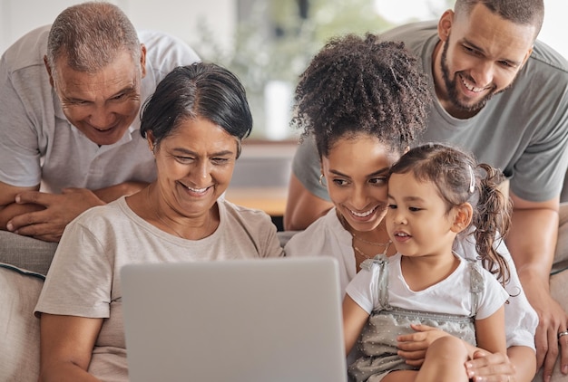 Family laptop child internet and grandparents watching funny video with children on the sofa in home living room and happy with comedy film Girl streaming show with parents and senior people