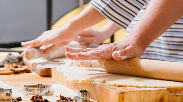 Family leisure and cooking hobby Cropped shot of mother and daughter rolling dough in flour making gingerbread biscuits