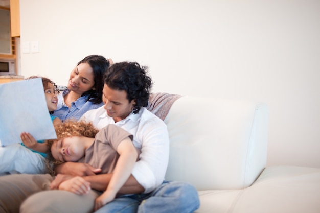 Family in the living room looking at photo album together