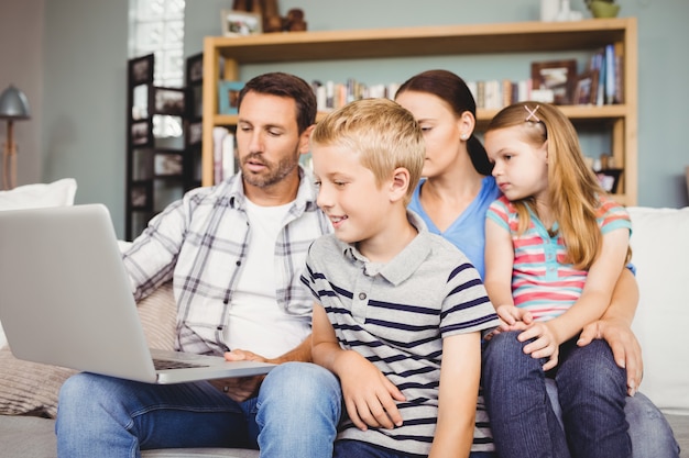 Family looking in laptop at home