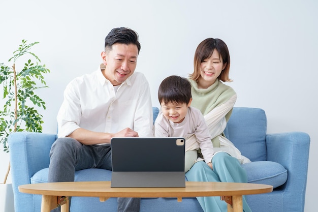 Family looking at the screen of a tablet PC indoors