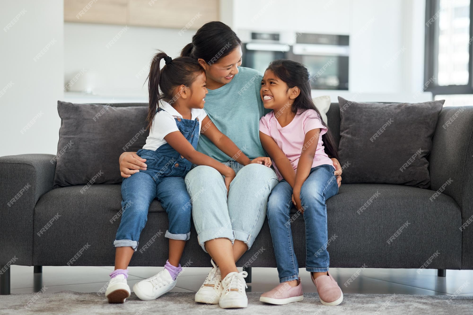 Family, video game and online gaming on home sofa with a pregnant mother  and daughter on a living room couch together while happy and having fun.  Woman and girl kid together for