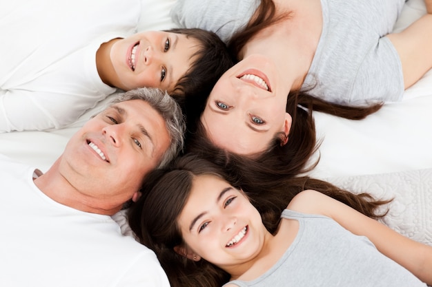 Family lying down on their bed