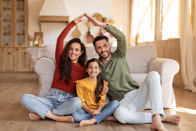 Family making a home shape with arms and hands