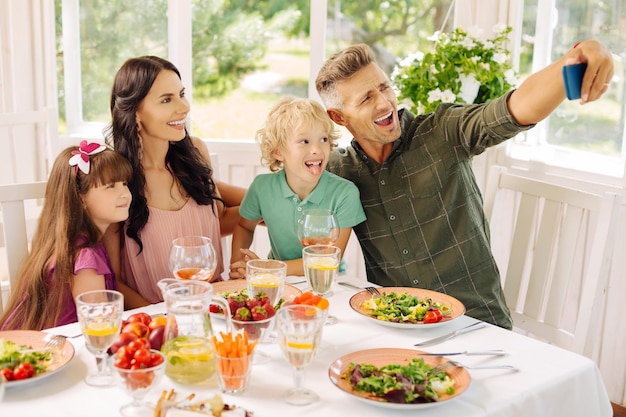 夏の家で昼食をとりながら自分撮りをする家族