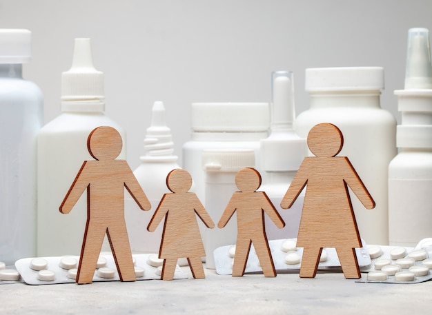 Family medicine. Dad, mom, daughter and son hold hands on the background of medicines.