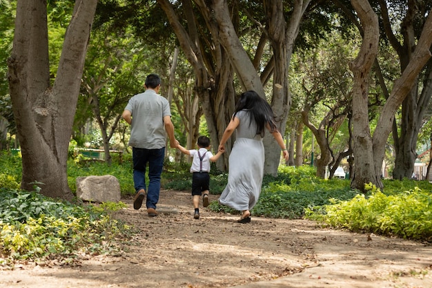 Family members holding hands and walking backwards in a park together family