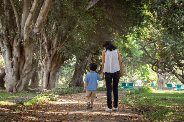 Family members holding hands and walking backwards in a park together family