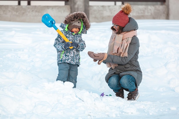 Family mom and child winter activity having fun together in the snow