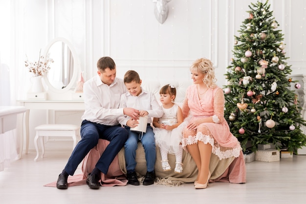 Family mom dad son and daughter on New Year's Eve. Congratulations and gifts on the Christmas holiday