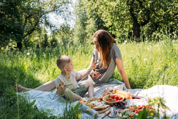 Family mom and son on picnic Smiling and enjoying summer on blanket in park