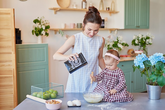 La madre della famiglia e la figlia del bambino nella mattina fanno colazione in cucina