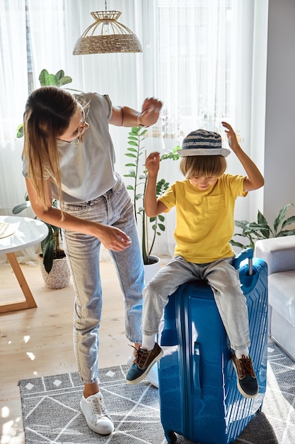 Family mother and child together packed a suitcase and have fun going on vacation or travel