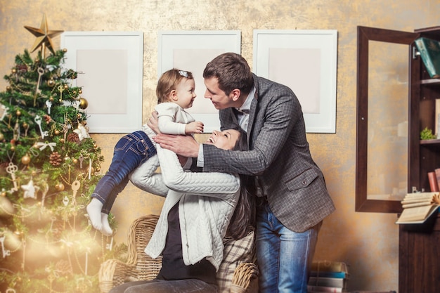 Family mother father and children with gifts in beautiful boxes in the Christmas interior