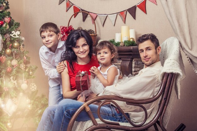 Family mother father and children with gifts in beautiful boxes in the Christmas interior