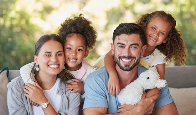 Family mother and father with foster children hugging in a happy portrait together love sharing quality time together Girls dad and mom are proud adoption parents of cute kids enjoying the weekend