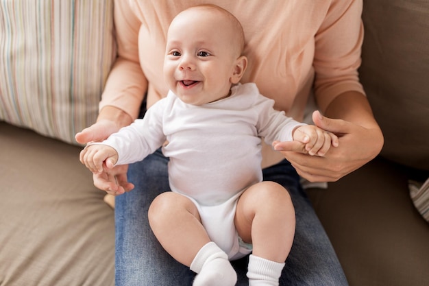 family motherhood and people concept mother with happy little baby boy at home