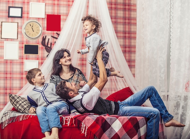 Family mum dad and kids together at home in the cosy atmosphere of the bedrooms in winter interior