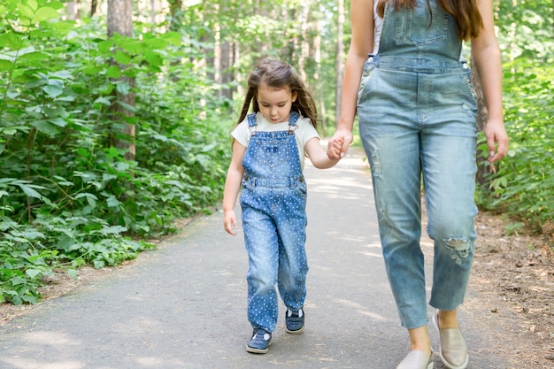 Ritratto di concetto di famiglia e natura di bella donna e bambino ragazza che cammina nel parco estivo