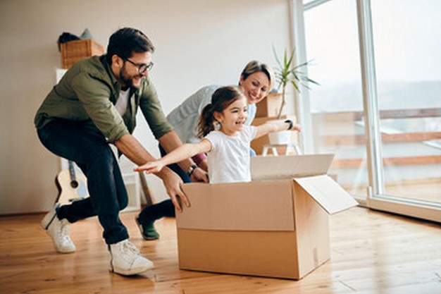 a family in a new home with a cardboard box that says quot family quot
