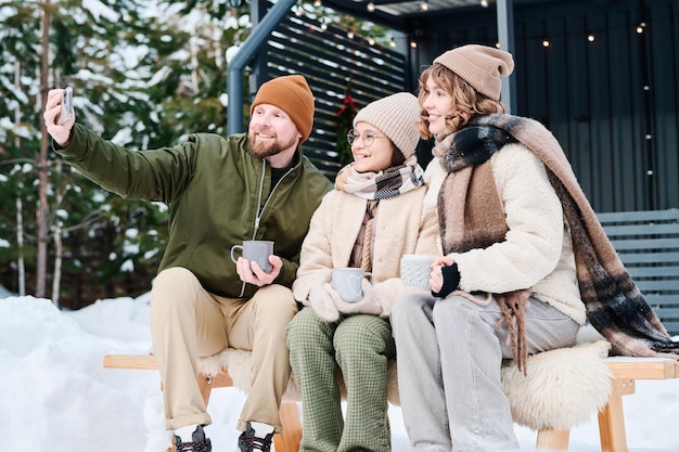 Фото Семья из трех человек делает селфи на открытом воздухе в зимний день