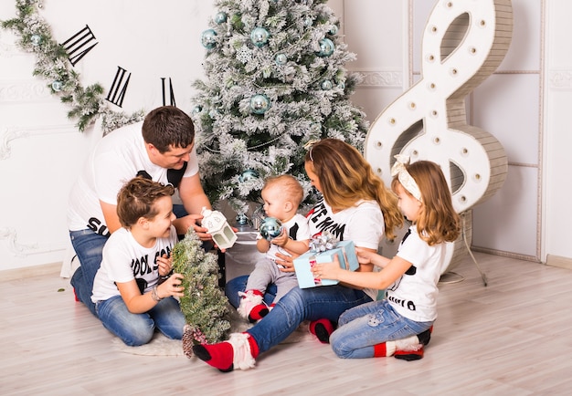 Family Opening Christmas Presents At Home Together.