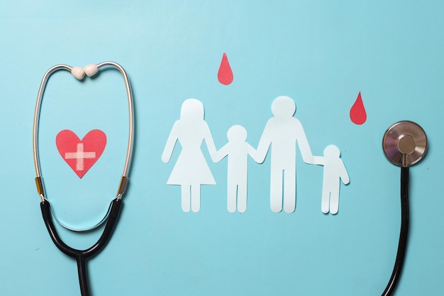 Family paper cut out with red heart paper blood drop symbol and stethoscope as symbol of World Bloo