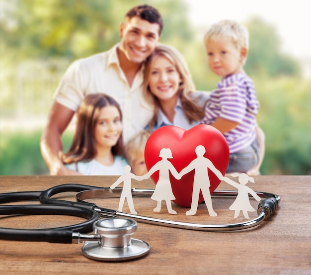 Family paper silhouette and stethoscope on wooden desk