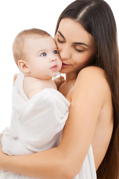 family, parenting and child care concept - happy mother kissing adorable baby