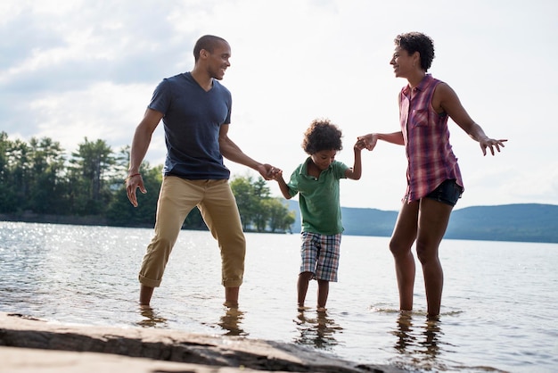 A family parents and son spending time together by a lake in summer