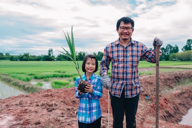 family people planting the tree on sky background