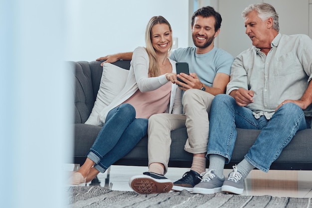 Family phone and relax on sofa in living room bonding and having fun Cellphone tech and happy man woman and grandpa on mobile smartphone on couch streaming video social media or web browsing