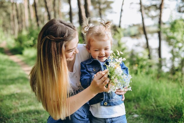 Family photo session on the street on a warm sunny day in a coniferous forest in spring