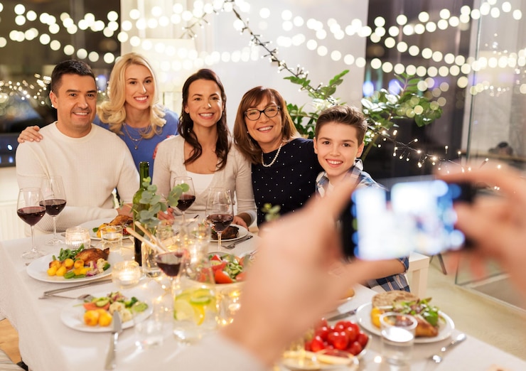 Photo family photographing by smartphone at dinner party