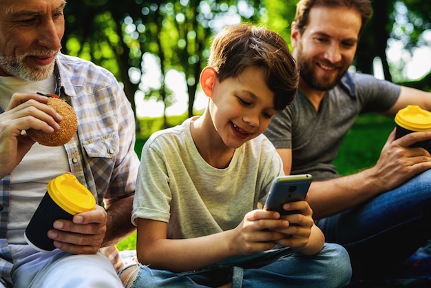 Family Picnic. Boy Watch Smartphone.