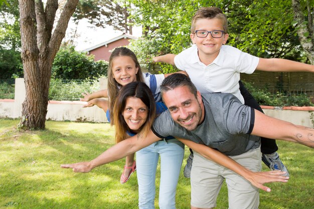 Family piggyback in garden house summer