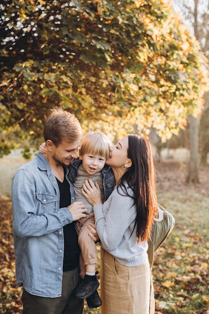 Famiglia che gioca nella sosta di autunno divertendosi