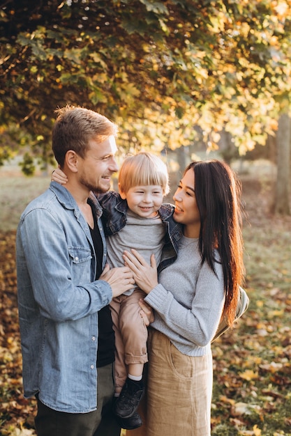 Family playing in autumn park having fun
