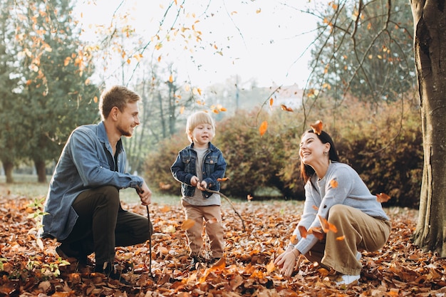 Family playing in autumn park having fun
