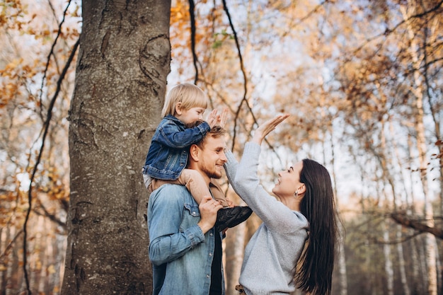 Family playing in autumn park having fun
