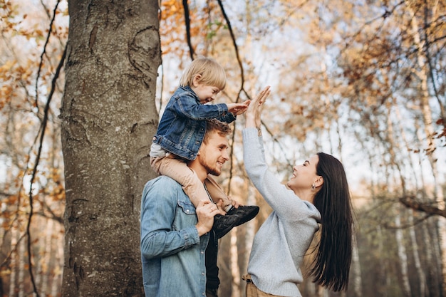 Family playing in autumn park having fun
