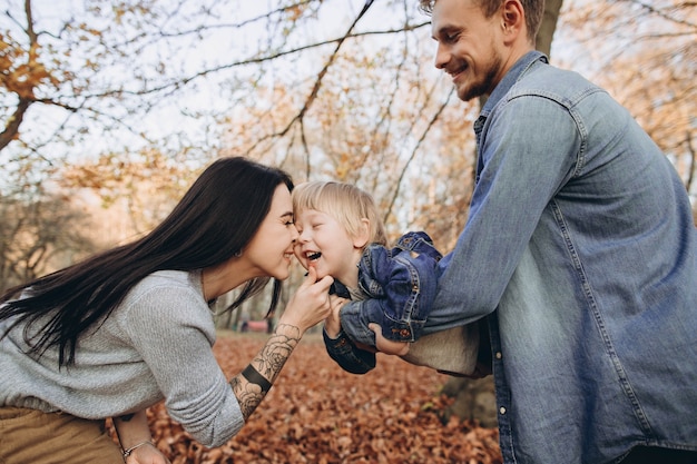 Photo family playing in autumn park having fun