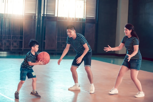 Family playing basketball on sports court